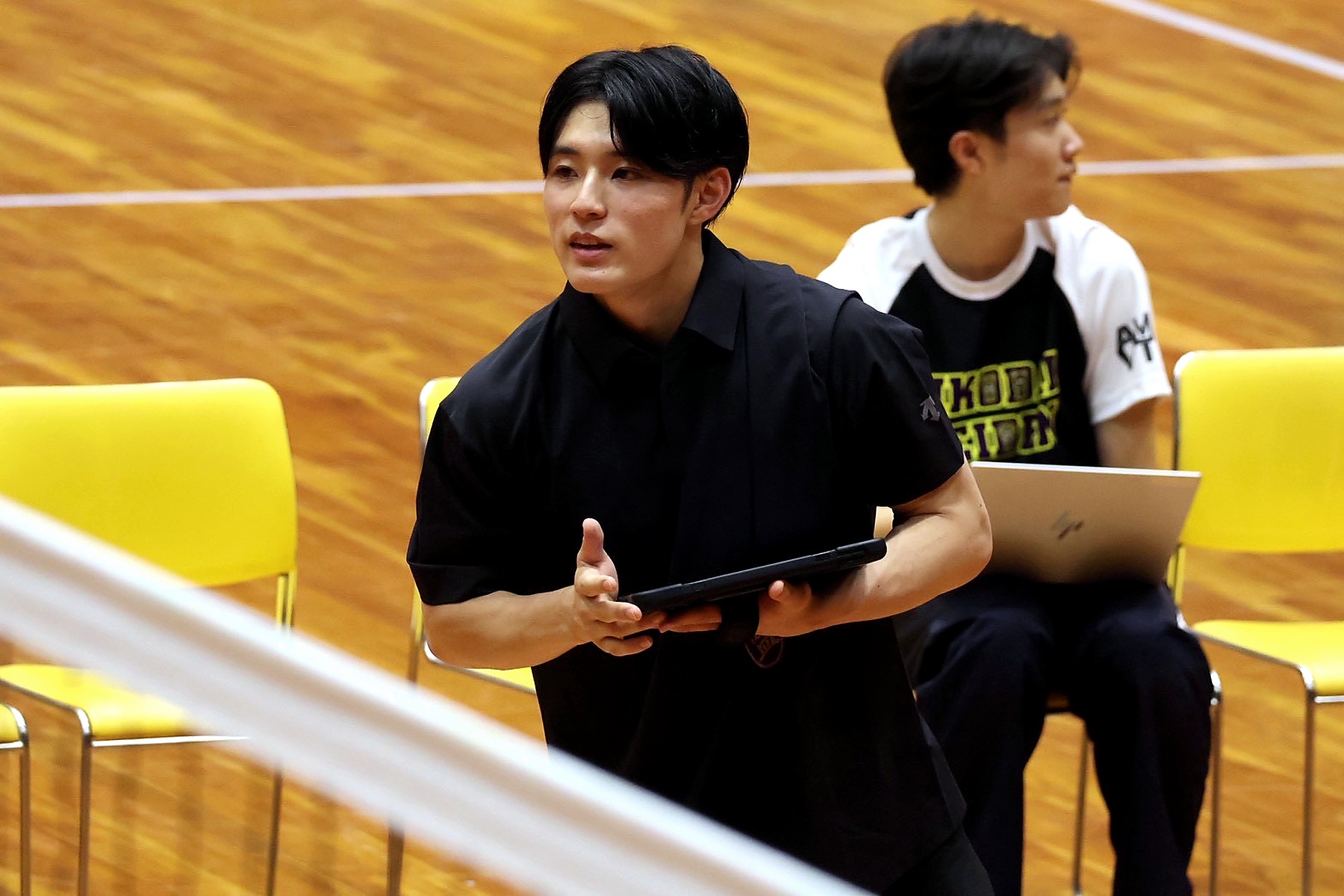 試合会場でタブレットを持ち、選手へ指示を出す藤巻睦監督